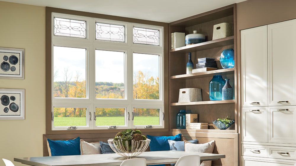 Modern blue house with large windows at dusk.