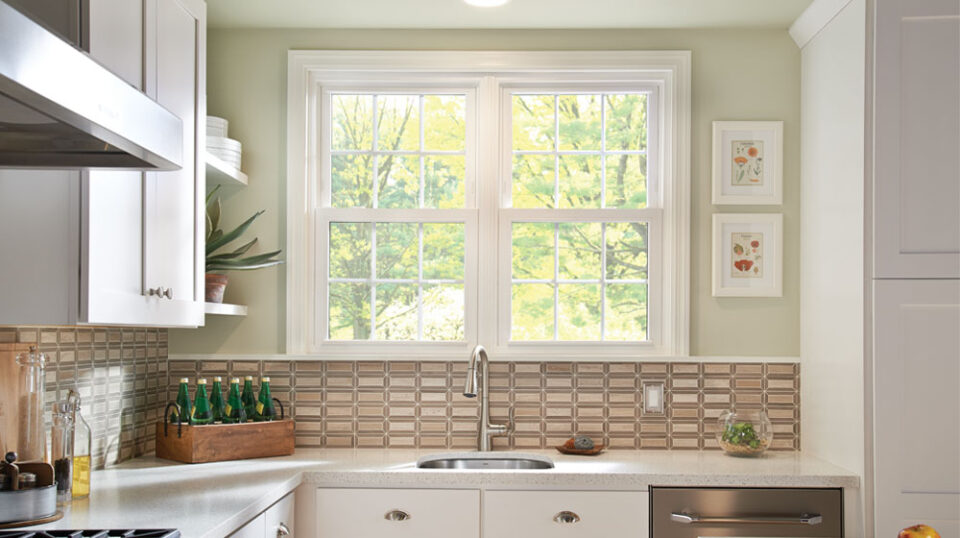 Modern kitchen with large window and backsplash tiles.
