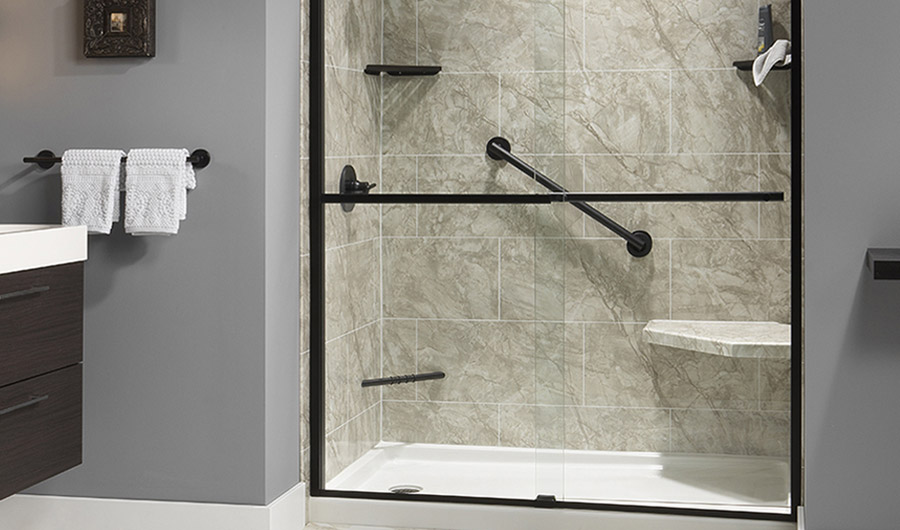 Modern bathroom with glass shower and gray tiles.