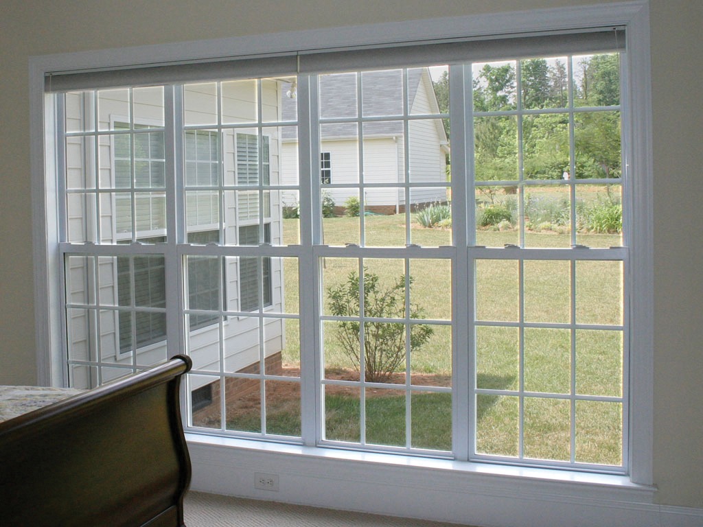 Large window overlooking garden and house exterior.