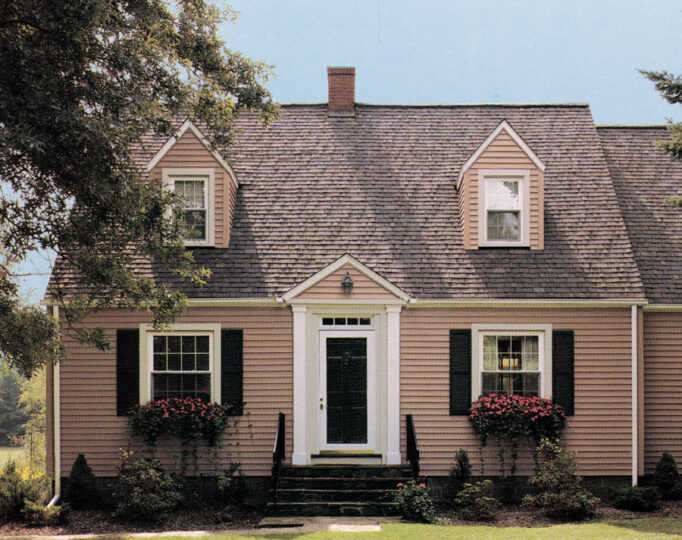 Charming pink house with dormer windows and garden.