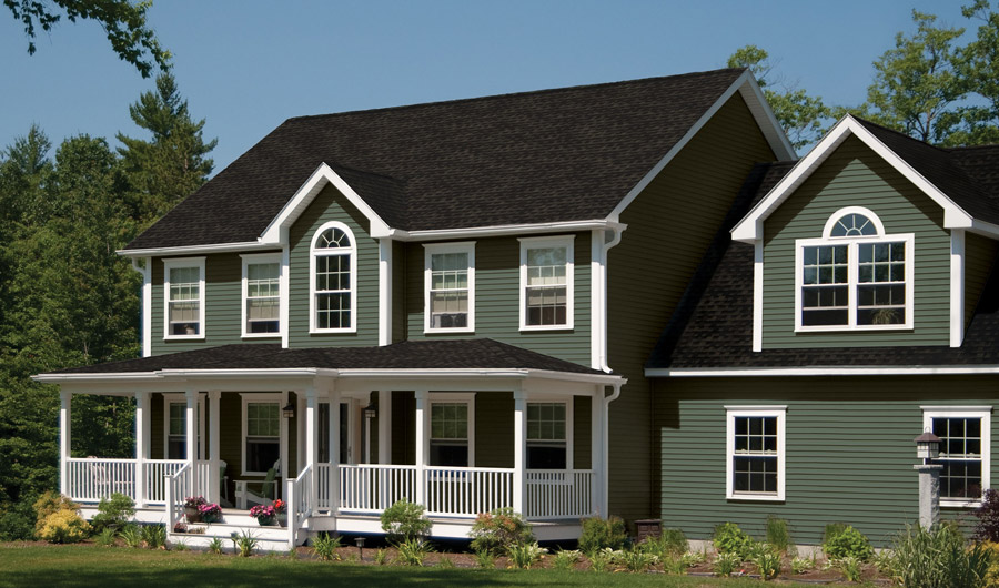 Green two-story house with porch and white trim.